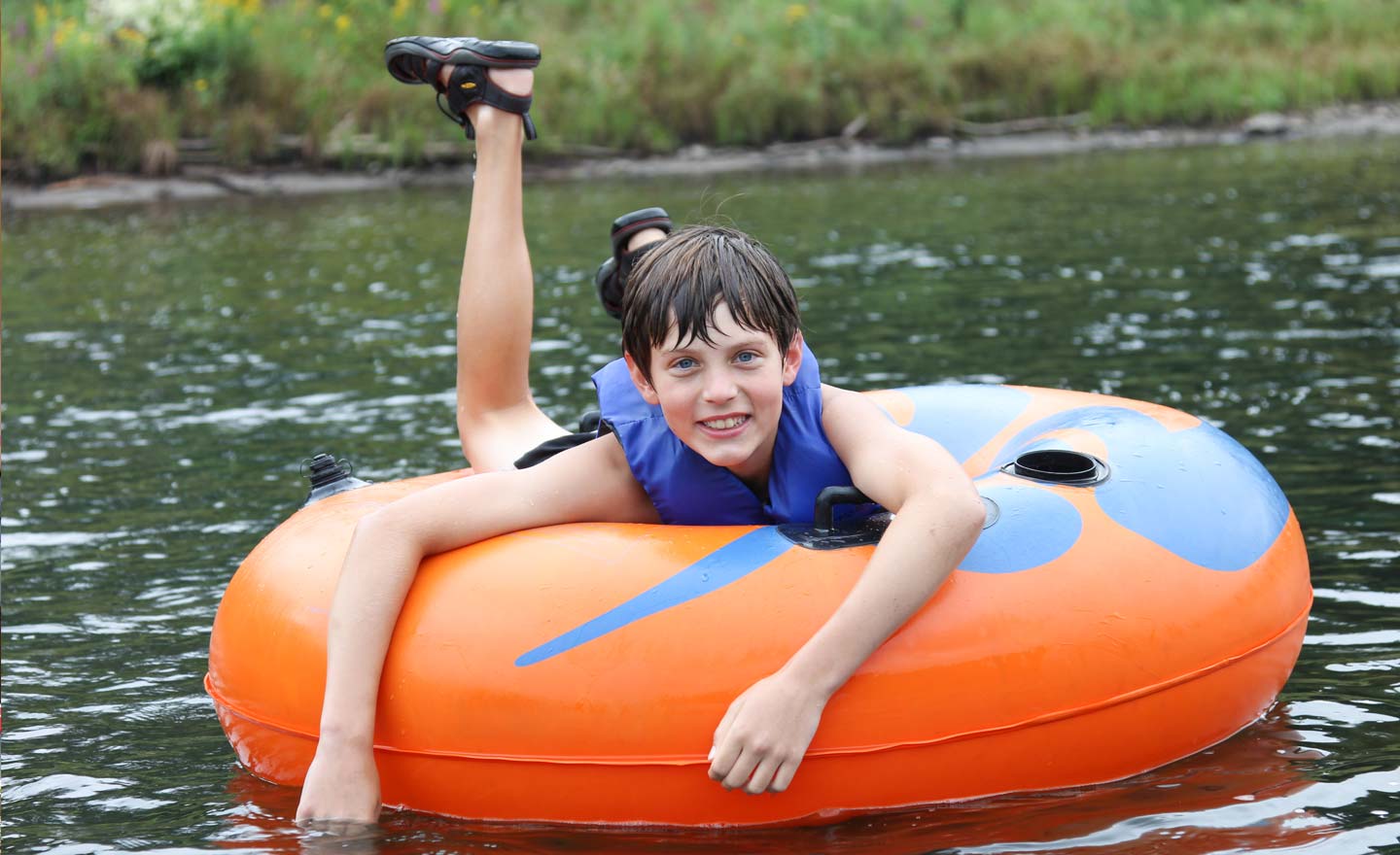 young boy smiling in tube on river Indian Head Canoeing Rafting Kayaking Tubing Delaware River