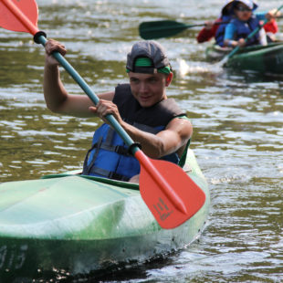 teen trying to come in first in kayak in Dingmans Ferry Indian Head Canoeing Rafting Kayaking Tubing Delaware River