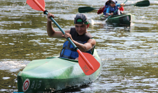 teen trying to come in first in kayak in Dingmans Ferry Indian Head Canoeing Rafting Kayaking Tubing Delaware River